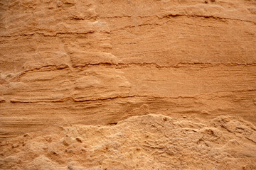 Textural sand, with relief surface, multi-colored layers and different in size of granules, in outdoor sand career, after mining ore and sand for construction.