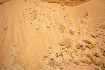 Textural sand, with  relief surface, multi-colored layers and different in size of granules, in outdoor sand career, after mining ore and sand for construction.