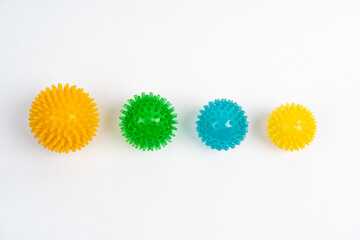 colored massage needle balls of different sizes on a white background, the concept of prevention of...