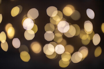 Dark background with bright orange glowing blurred different lights. Festive concept close up.