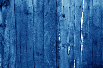 Wall made of uncutted weathered wood boards in navy blue tone.