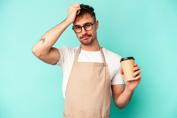 Young store clerk man holding a coffee isolated on blue background being shocked, she has...