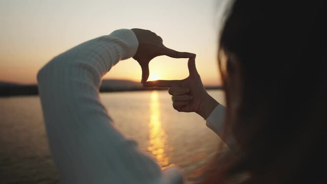B roll - New year planning and vision concept, Close up of woman hands making frame gesture with sunset, Female capturing the sunrise.