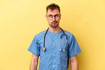 Young nurse caucasian man isolated on yellow background confused, feels doubtful and unsure.