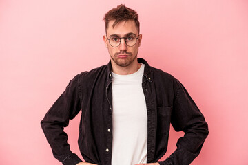 Fototapeta premium Young caucasian man isolated on pink background confused, feels doubtful and unsure.