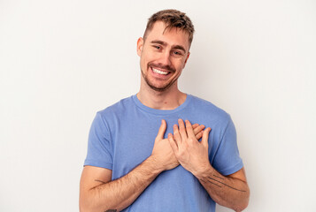 Young caucasian man isolated on white background showing a copy space on a palm and holding another hand on waist.