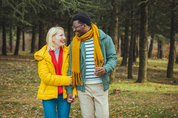 Fototapeta premium Young couple in love walking on pathway through grass field. Young couple on vacation , they enjoy in summer. They walking through forest, exploring nature