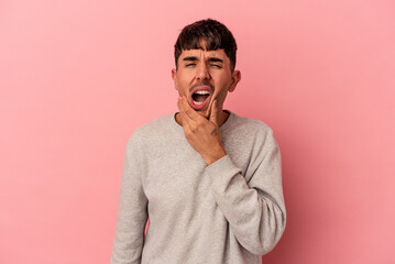 Young mixed race man isolated on pink background having a strong teeth pain, molar ache.