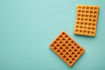 Two waffles on blue background with copy space
