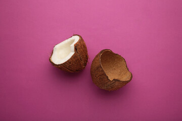 Coconut on pink background. Halves of coconut. Top view.