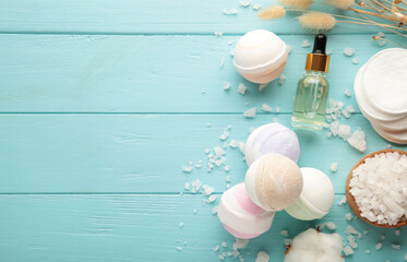 Aroma bath bombs in spa composition with dry flowers and salt on blue background.