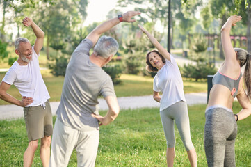 Group of people doing morning exercises in the park