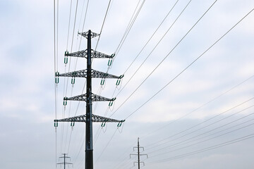 High voltage towers with electrical wires on sky background. Electricity transmission lines, power supply concept