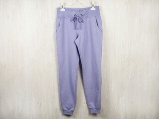 Women's, youth clothes. Lilac sweatpants hang on a hanger.