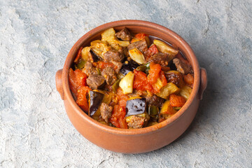Top view of Turkish dish Guvech - baked meat with eggplant and traditionally served in earthenware pot (Turkish name; etli patlican guvec)