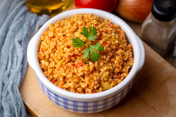 Traditional turkish bulgur pilaf with tomato sause in plate (Turkish name; meyhane pilavi)