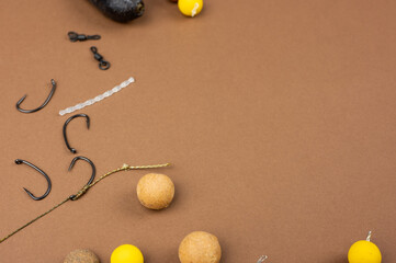 Carp fishing gear close up on the brown backdrop. Fishing tackle concept in the studio. Copy space