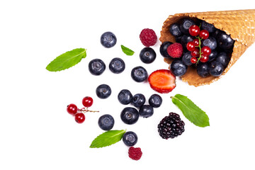 Fresh different berries assortment and mint leaves in waffle cone. Ice cream cone with ripe sweet berries on white background with copy space. Summer creative concept, flat lay, Top view