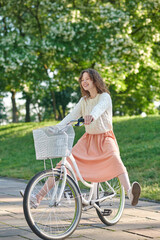Fototapeta na wymiar A cute ginger girl on bike in the park