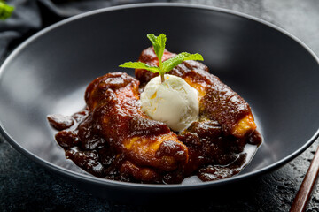 Fried bananas with ice cream  on black bowl, Chinese cuisine macro close up