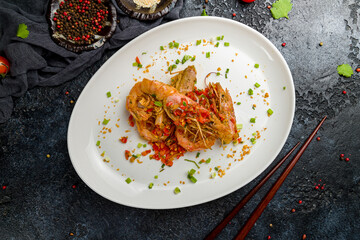 some langoustines on a plate on dark stone table, Chinese cuisine top view