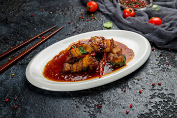 Pork in chili sauce with rice Chinese cuisine on dark stone table