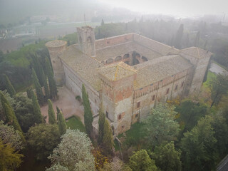 Aerial view of castle in Magione in dense fog near Lake Trasimeno in Umbria, Italy