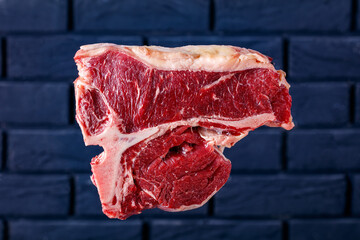 porterhouse steak in front of brick wall