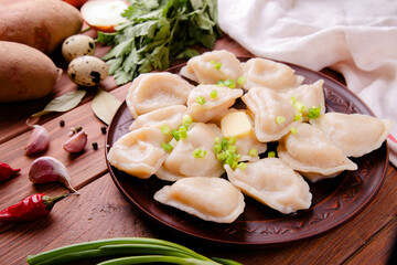 Raw dumplings with cabbage on a wooden background
