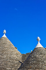 Fototapeta na wymiar Trullidächer in Alberobello, Apulien, Italien unter blauem Himmel