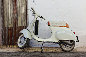 Ein Motorroller steht an einer Hauswand