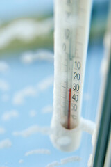 Classic mercury thermometer for measuring ambient temperature, hanging outside the window, with readings minus 30 degrees Celsius.