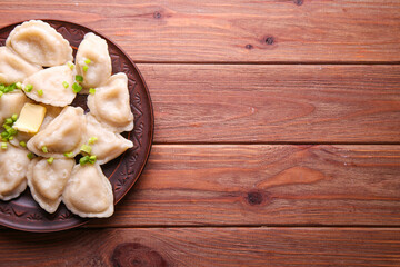 Dumplings with potatoes on a wooden background with place for text. Vareniki is a dish of Slavic cuisine.