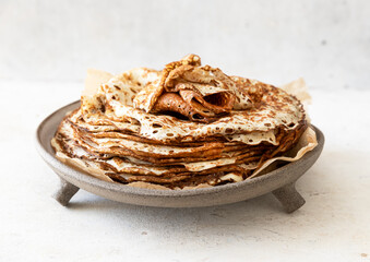 Stack of traditional russian pancakes blini on wooden background. Maslenitsa traditional Russian festival meal.