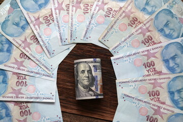 A lot of Turkish lira banknotes against one hundred dollar banknote. Turkish economy, exchange...