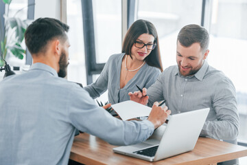 Sitting by the table. Group of business people that working on the project in the office