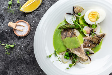Fish dish - fried fish fillet of zander served with mussels, peas, asparagus and vegetable cream...