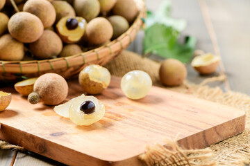 Fresh longan fruits on wood plate and old wood background,