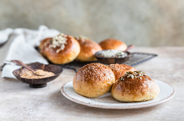 Fresh homemade pumpkin buns with brown sugar or seeds, concrete background.