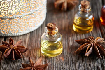 A bottle of aromatherapy essential oil with dried star anise spice