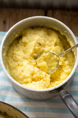 Cooked polenta dish, with parmesan, butter, salt and pepper . Polenta is made when cornmeal is boiled in water and chicken stock.