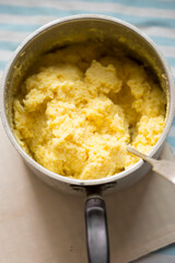 Cooked polenta dish, with parmesan, butter, salt and pepper . Polenta is made when cornmeal is boiled in water and chicken stock.