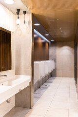 Public empty restroom with washstands and urinals
