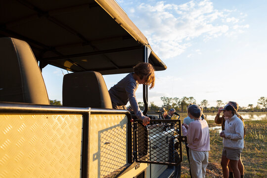 People enjoying a sundowner, drinks at sunset on a safari drive. 