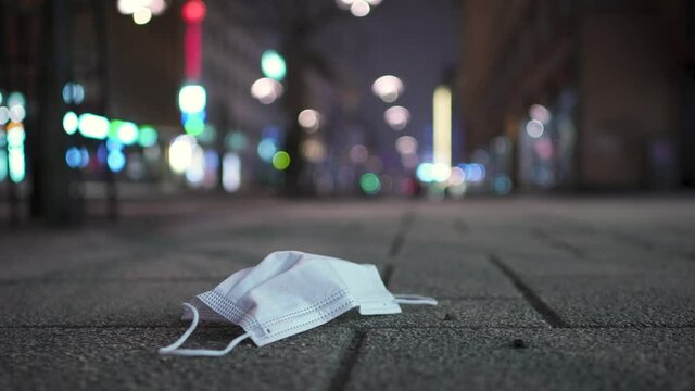 Used face mask left on an empty city street