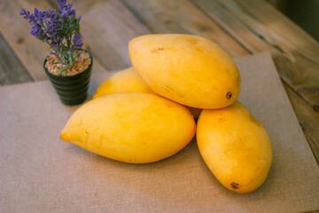 The golden mango is placed on the floor wooden table.