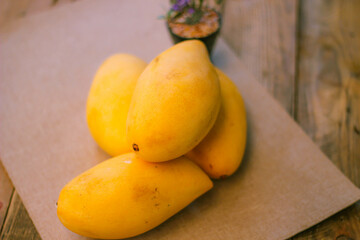 The golden mango is placed on the floor wooden table.