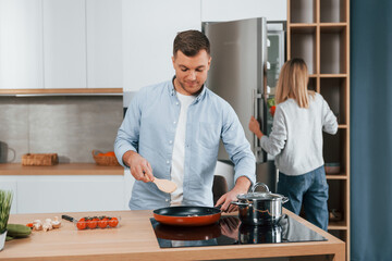 Preparing dinner. Couple at home on the modern kitchen