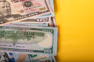 Wealth. A lot of money American paper banknotes. Background from money on a yellow background.