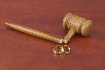 Wedding rings and broken judge gavel. Marriage out of law concept.	